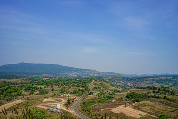 A picture of a landscape of a community in a central valley with mountains and blue skies.