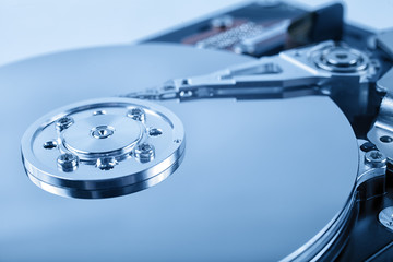 Disassembled computer hard drive with mirror disks. Toned blue color. Soft focus.