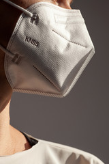 Young woman wearing KN-95 protection medical mask. Prevention of the spread of virus and epidemic, protective mouth filter mask. Diseases, flu, air pollution, corona virus concept