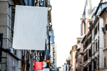 Fototapeta na wymiar Hanging rectangular blank flag on the street in the city - Image