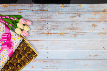 Beautiful chocolates for special day with gifts and tulips
