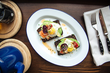 Breakfast rye toast with avocado poched egg salmon