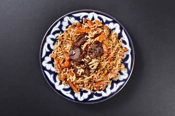 Plov pilaf plate on black background. Traditional Uzbek cuisine.  Top angle - 346023925