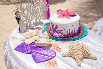 Tropical wedding cake for bride and groom to cut during destination wedding marriage outdoor ceremony on the sandy beach in Dominican republic 