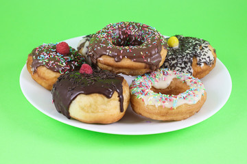 Donuts glazed with chocolate on plate 