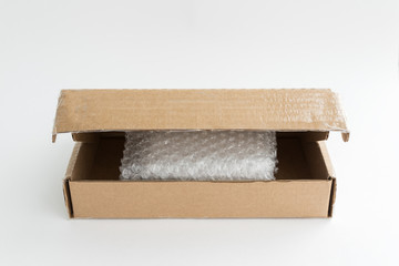 opened cardboard box with transparent bubble wrapping film inside, ready for packing goods into box, delivery of online shopping order, online delivery concept