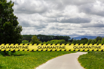 Coronavirus quarantine warning tape with empty park on the background. Covid-19 lockdown concept