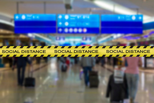 Social distance warning tape with blurred airport image on the background. Coronavirus, covid-19 social rules or guides