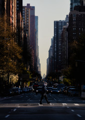 Man  crossing the street with a mask on in Midtown
