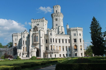white light castle against the blue sky and green grass lawn