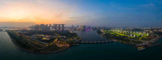 Fototapeta premium Drone view of Singapore Gardens by the Bay botanical gardens and Marina bay sands at twilight