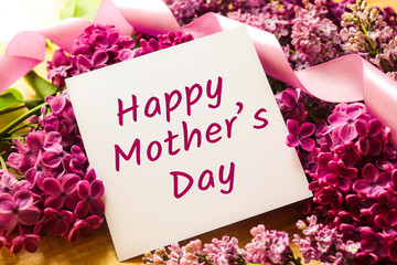 Greeting card on a background of lilac with a purple ribbon. Happy Mother's Day card. A beautiful gift card.