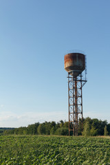 Water tower, sunlight and against a cloudy sky at dusk.
