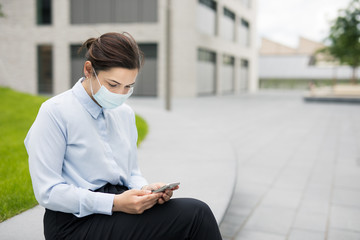 Frau mit Smartphone macht Pause vor Bürogebäude auf Campus oder Technologiepark. 