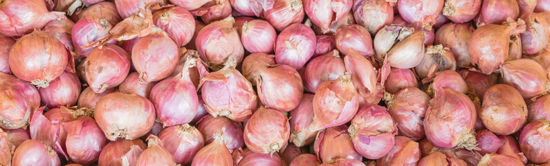 Panoramic view heap of raw yellow onions on display at market stand in Little India, Singapore