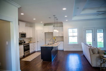 New construction modern kitchen with white cabinets and hardwood floors