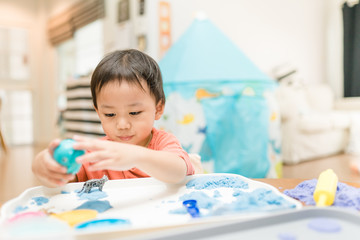 Asian kid boy and siblig girl stay at home lockdown from covid-19 coronavirus crisis are playing science sand playing sand basket at home.Concept for Executive Functions and motor skill.Stay home.