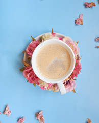 Coffee cup with flower decoration. The background is blue.