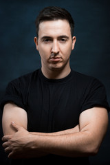 Obraz premium Handsome muscular young man on dark with stern expression