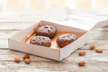 Selective focus of sweets made by chocolate and almond in the open box on the wooden table.