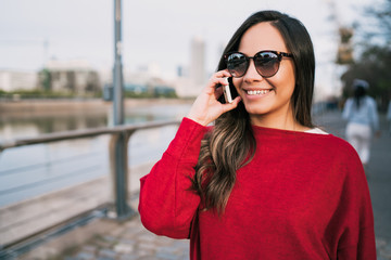 Fototapeta premium Latin woman talking on the phone.
