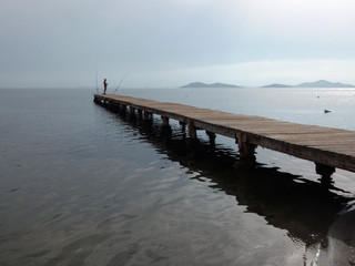
wooden pier goes into the sea to the horizon in foggy weather side view
