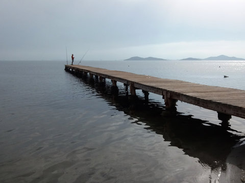 
Wooden Pier Goes Into The Sea To The Horizon In Foggy Weather Side View