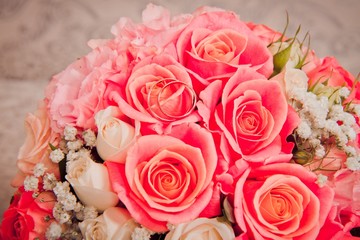 Bride's bouquet with wedding rings on it. Bright wedding bouquet of scarlet roses. close-up