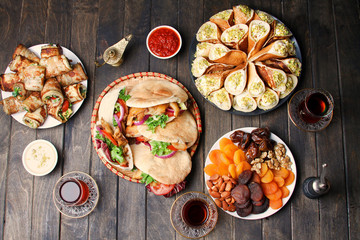 Traditional Ramadan Food (Dry Fruits And Nuts, Shawarma, Qatayef, Eggplant Rolls, Sauces And Glass Of Tea. Top View. Flat Lay.