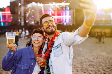 Couple in love drinking beer and having fun at music festival. Beach party, summer holiday, vacation concept. 