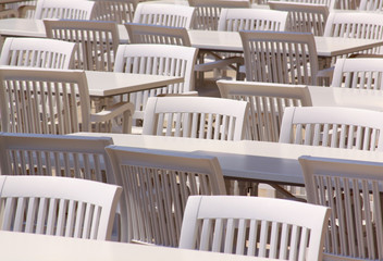 White plastic tables, chairs on restaurant terrace