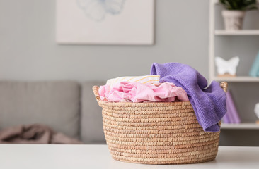 Fototapeta na wymiar Basket with laundry on table in room