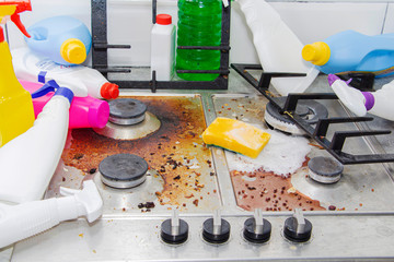 dirty kitchen stove, empty and full bottles of detergents around.