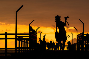 Fototapeta na wymiar Silhouette girl photographer on pier at sunset