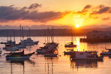 Fototapeta na wymiar Blazing sky at sunrise over the fishing boats at Monterey Bay.