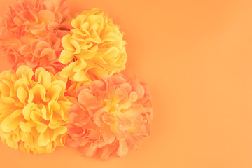 Fondo de pantalla con unas hermosas flores artificiales de color naranja y amarillo