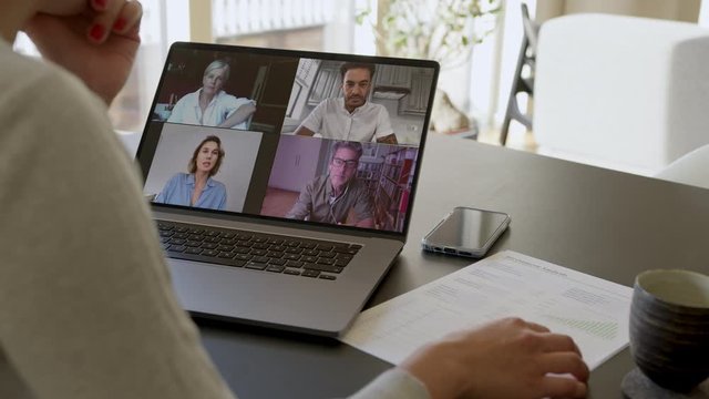 Businesspeople having a video conference meeting. Woman sharing her ideas with colleagues during an online meeting from home.  
