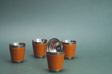 Metallic shot glasses and funnel. travel shot glass for alcohol with leather casing over the...