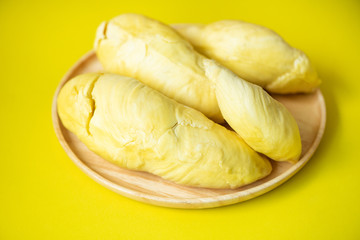 Ripe durian tropical fruit summer for sweet dessert or snack in Thailand - Durian fruit fresh from tree peel on wooden plate yellow background