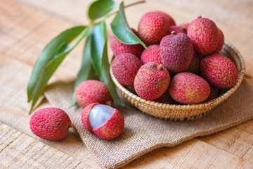 Lychee slice peeled on wooden - Fresh lychee with green leaves harvest in basket from tree tropical fruit summer in Thailand