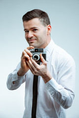 Smiling young man with vintage photo camera