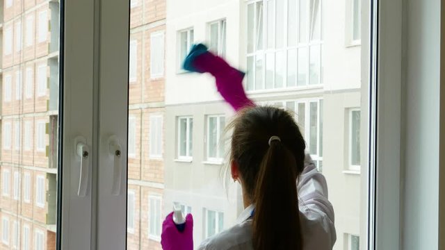 Beautiful young brunette girls stand with their backs and do the cleaning.