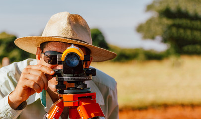 Man used digital level to adjust soil position for planting - Land preparation and contour line