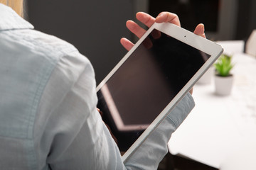 Beautiful white girl working in an office behind a tablet. Copy space. Engineering works in isolation
