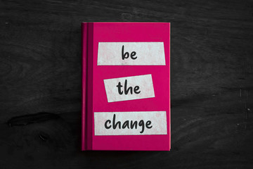 A pink book with a simple three worded message written on the front. 