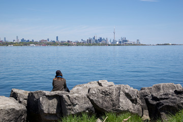 Fototapeta na wymiar single sitting on the rock overlook the cityscape of Toronto, Canada
