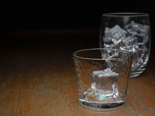 Two glasses with ice cubes on the countertop