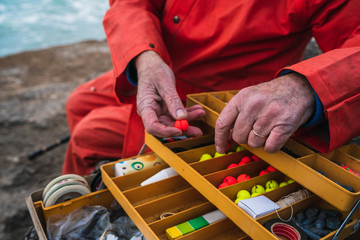 Fisherman with fishing equipment box.