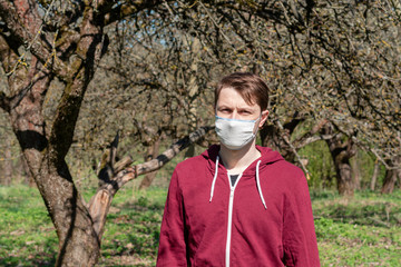 the man is in the forest. reusable gauze mask on the face to protect against coronavirus. pandemic...