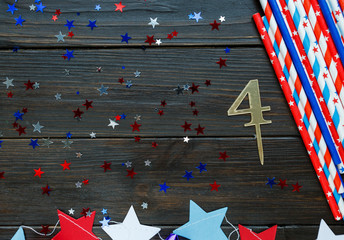 Decorations for 4th of July day of American independence, flag, candles, straws. USA holiday decorations on a wooden background, top view, flat lay